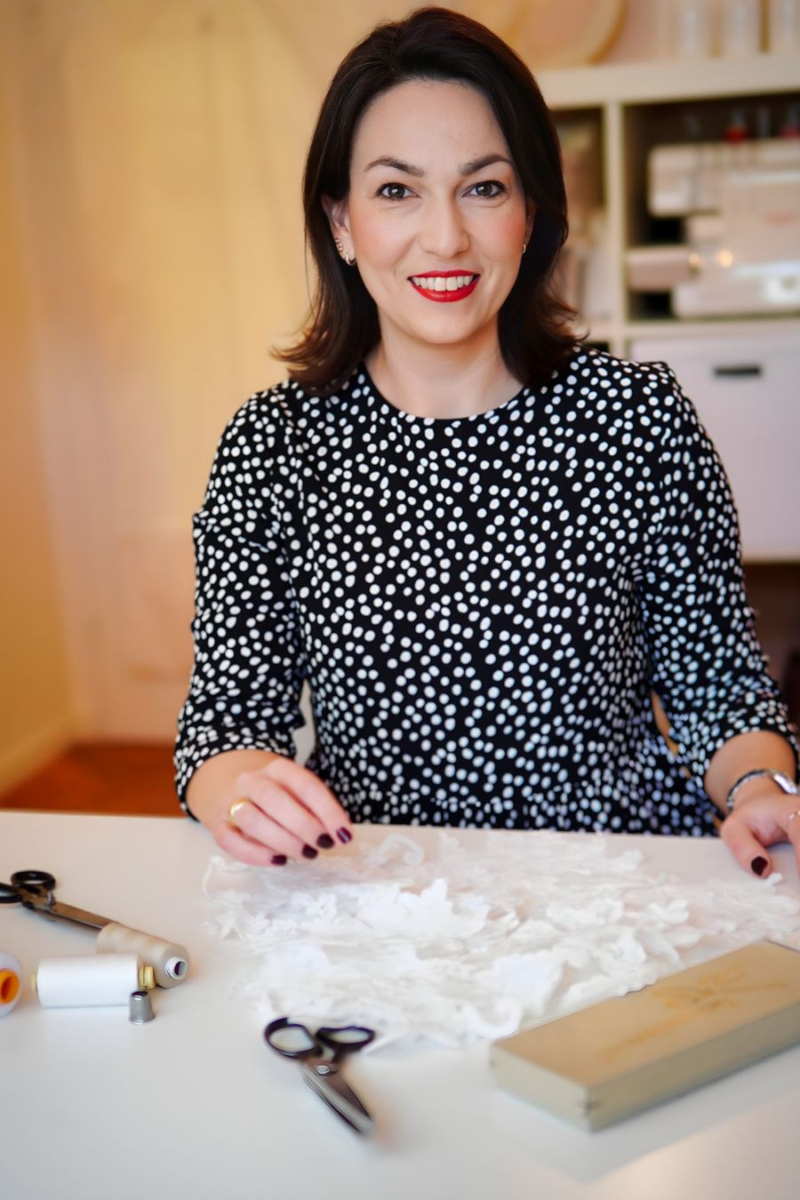 Simone Stark in ihrem Atelier, abgebildet mit Spitze, Schere, Nadel und Faden Simone Stark in ihrem Atelier, abgebildet mit Spitze, Schere, Nadel und Faden