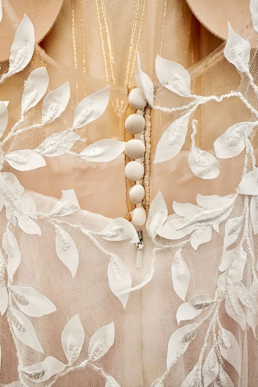 Detailfoto eines Brautkleides mit tiefem Rückenausschnitt, Kopfleiste und Blätterspitze Detailfoto eines Brautkleides mit tiefem Rückenausschnitt, Kopfleiste und Blätterspitze