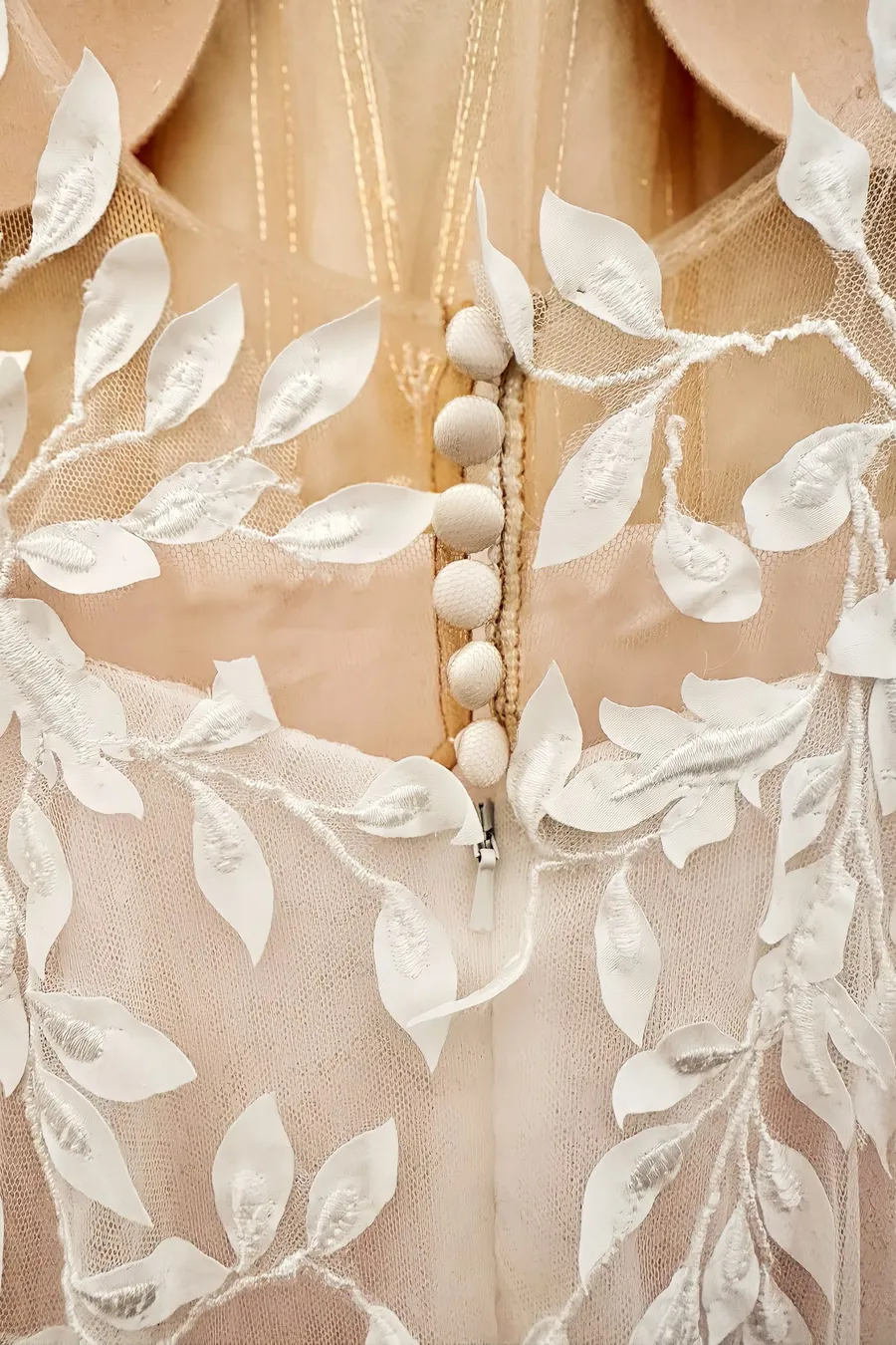 Detailfoto eines Brautkleides mit tiefem Rückenausschnitt, Kopfleiste und Blätterspitze