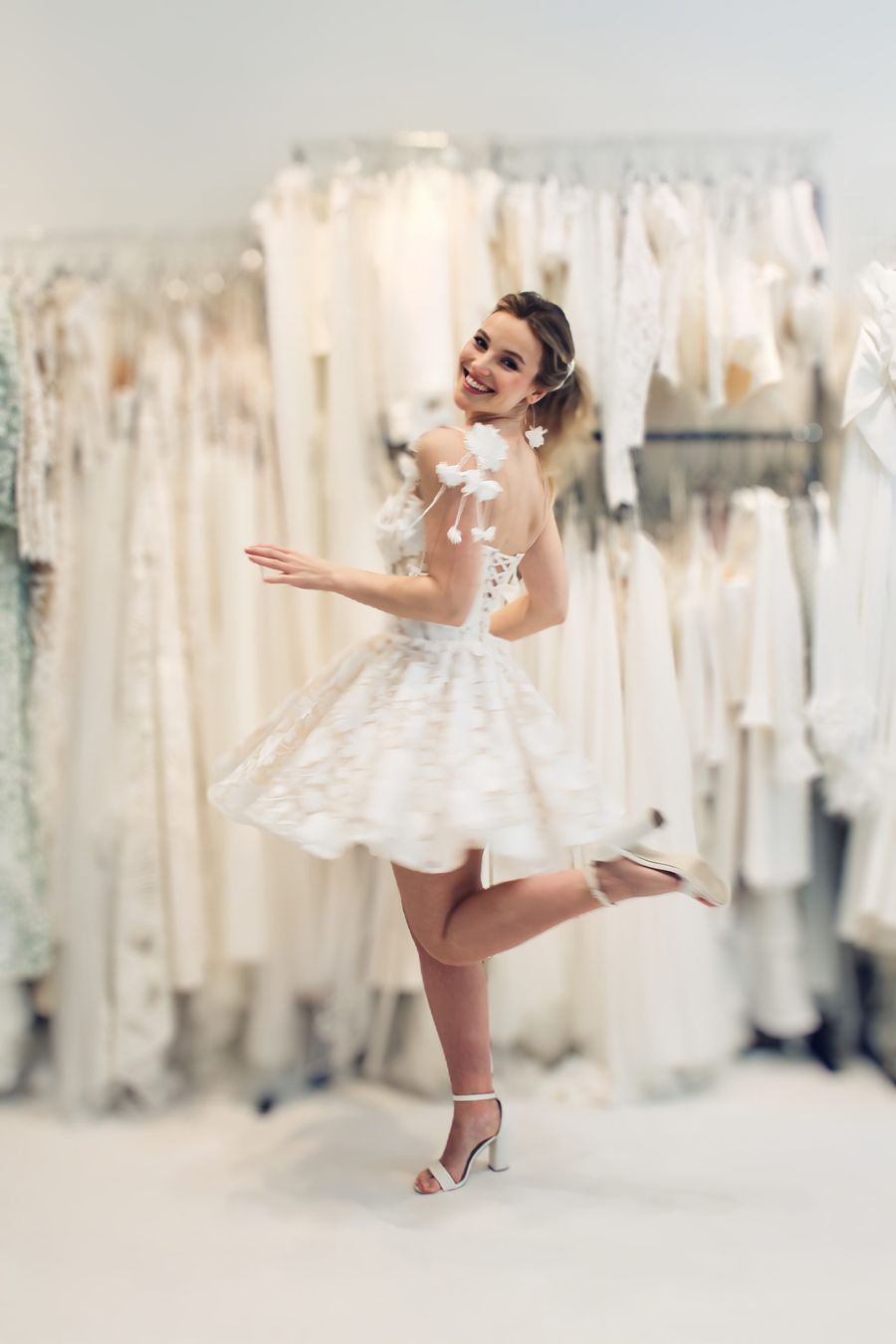 tanzende Braut in kurzem Brautkleid mit 3d Blüten an der Schulter tanzende Braut in kurzem Brautkleid mit 3d Blüten an der Schulter