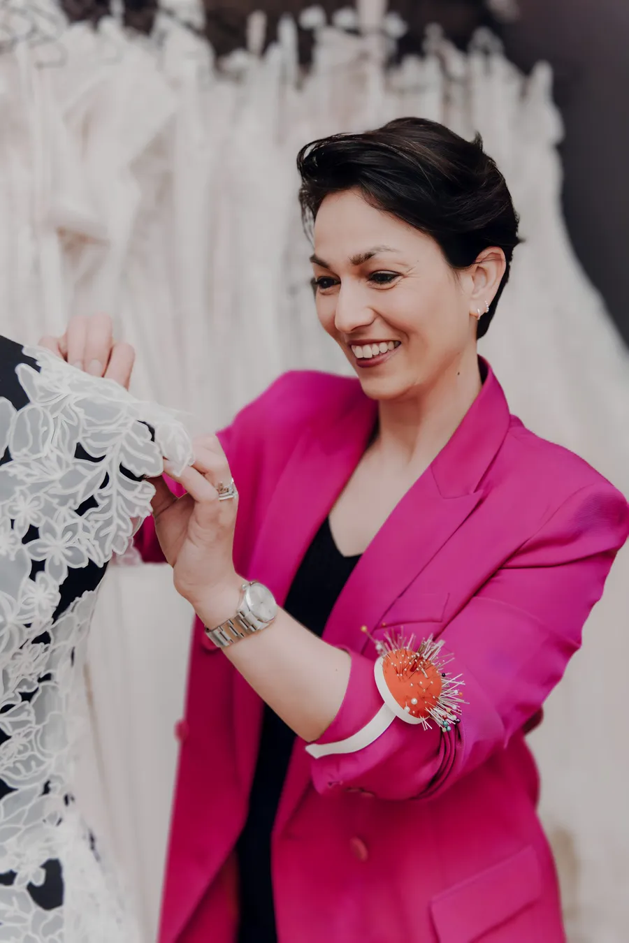 Simone steckt ein ganz besonderes Brautkleid ab, denn der Stoff besteht nur aus aneinandergesetzten Blüten und Blättern und lächelt dabei