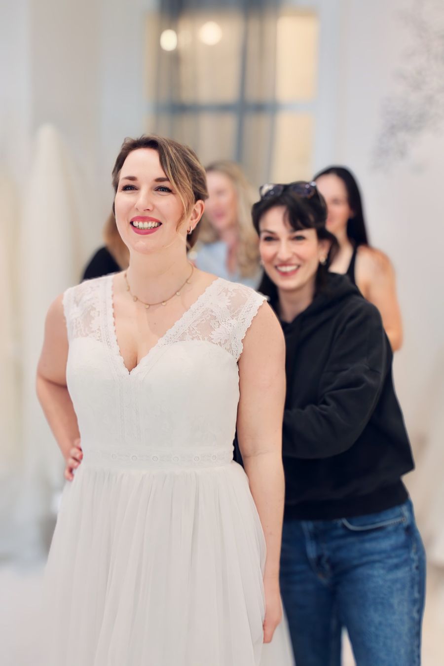 Wir finden Dein perfektes Brautkleid während der Anprobe hilft Simone der Braut und passt das Brautkleid an, damit es perfekt sitzt und sich die Braut im Spiegel betrachten kann