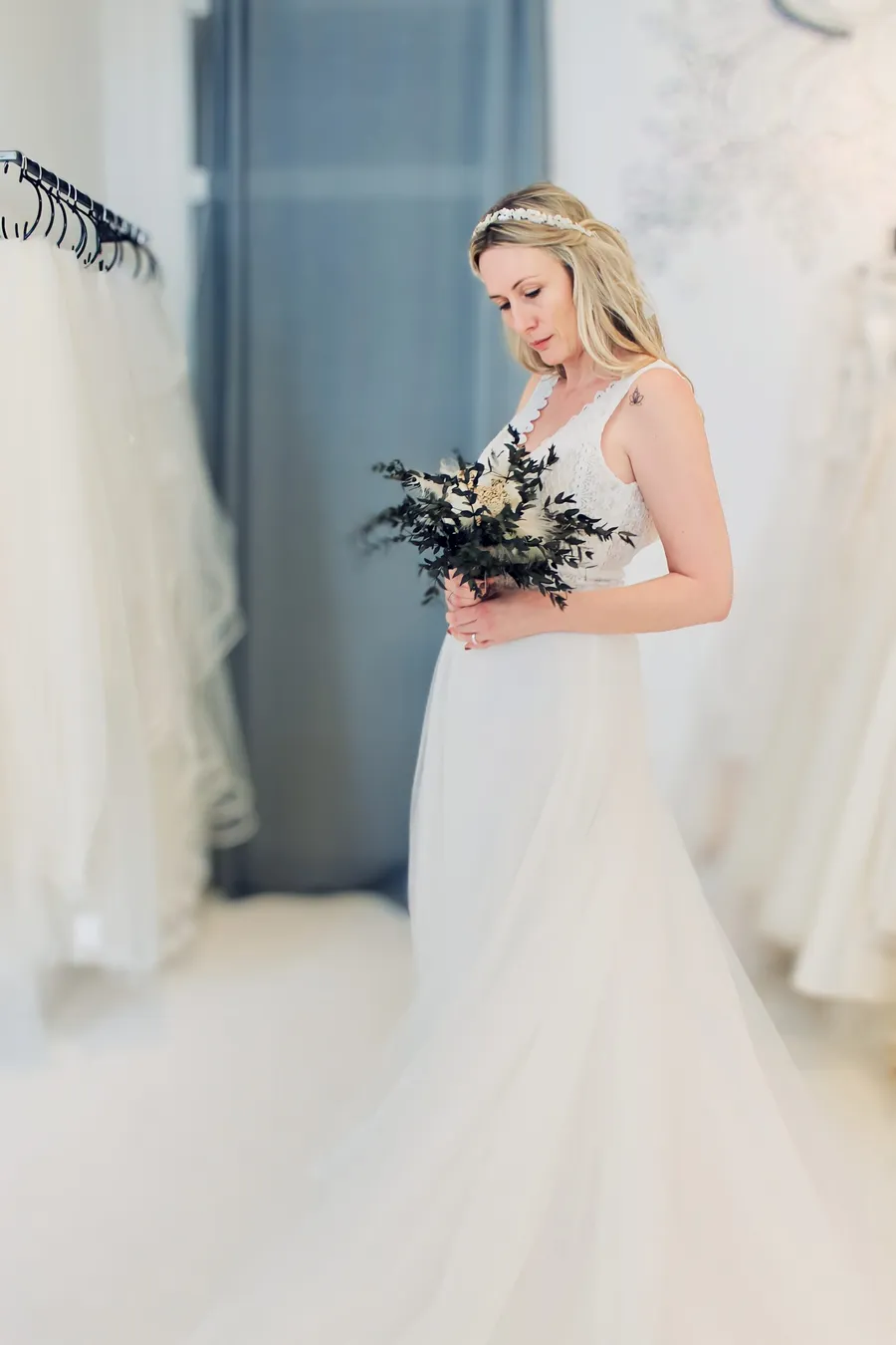 Braut in der Anprobe mit Brautstrauß in einem Second Hand Brautkleid