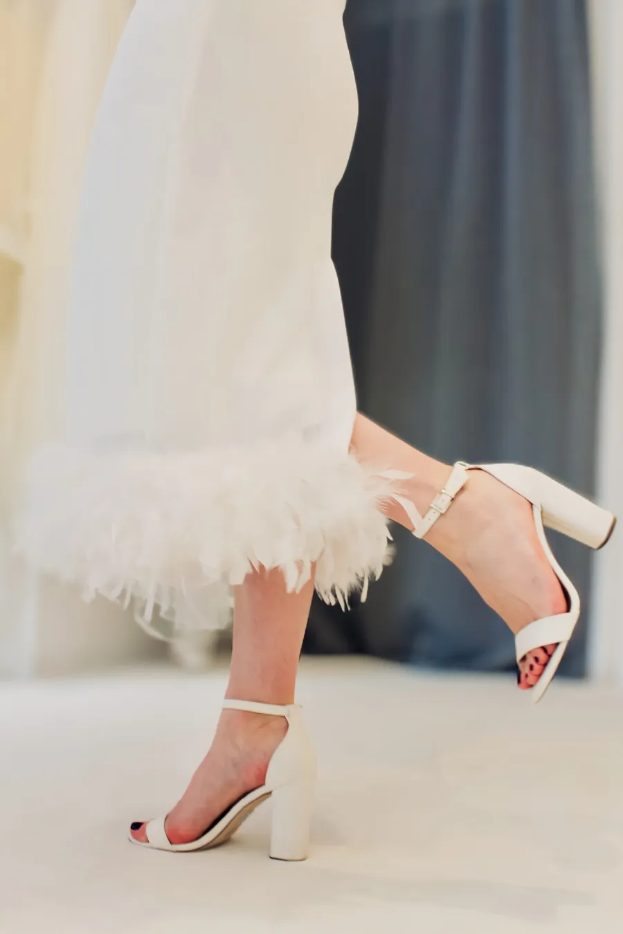 Brautkleid in 7/8 Länge mit Federn am Saum für den besonderen Touch und High Heels mit Blockabsatz